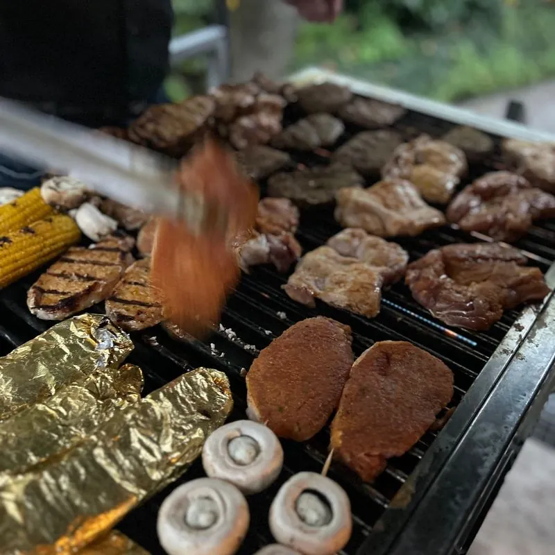 Steaks, Maiskolben und Champignons auf dem Grill