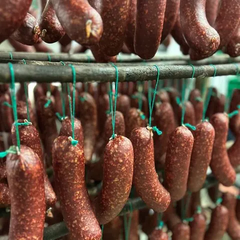 Trockenwürste hängen in der Reifekammer
