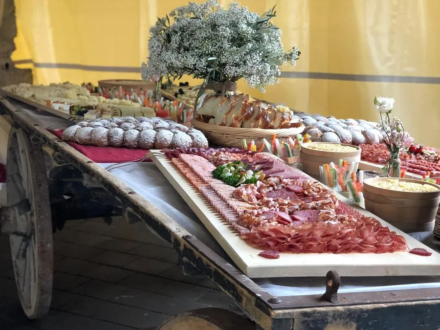 Apéro-Buffet mit Fleischplatte, Wurst und Brot auf einem alten Leiterwagen