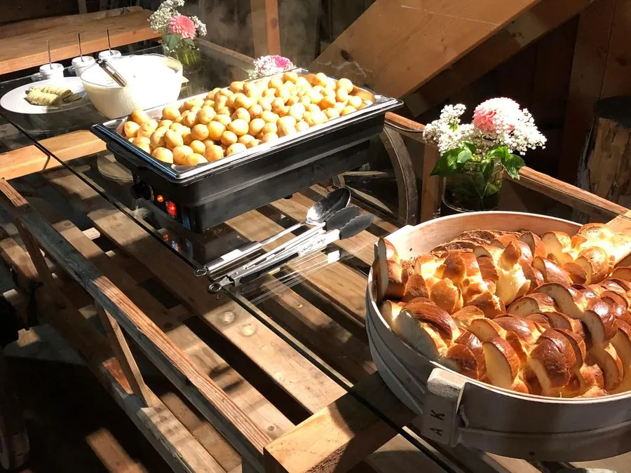 Buffet mit Kartoffeln im Warmhalter und Brot im Korb