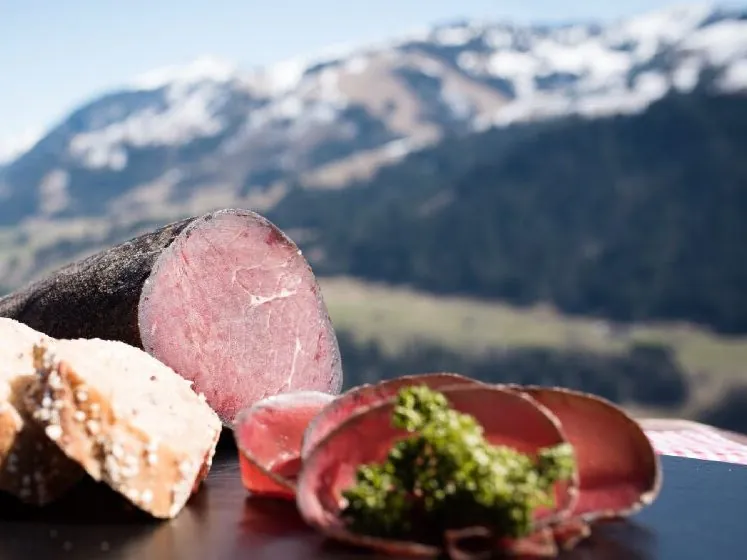 Angeschnittenes Simmentaler Trockenfleisch, dahinter die Simmentaler Berge