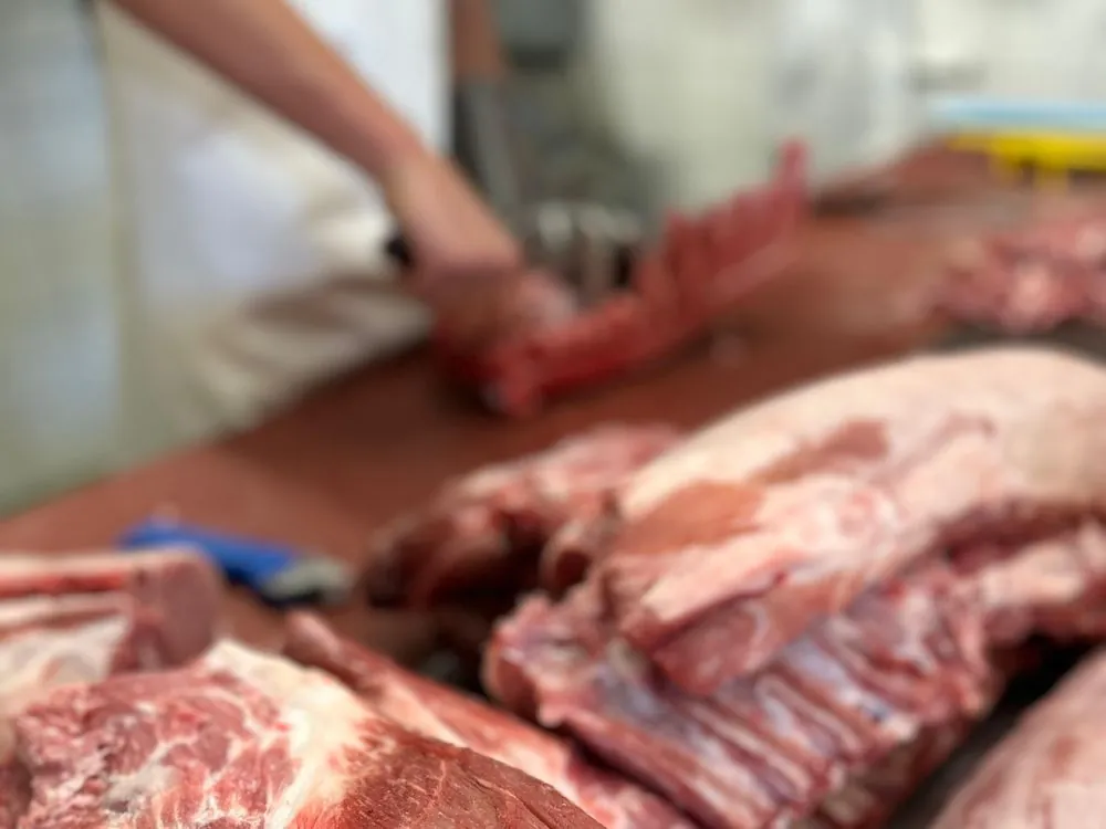 Metzger zerlegt Schweinefleisch am Schneidetisch
